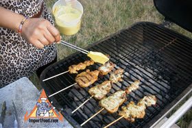 Baste the marinated skewers of pork