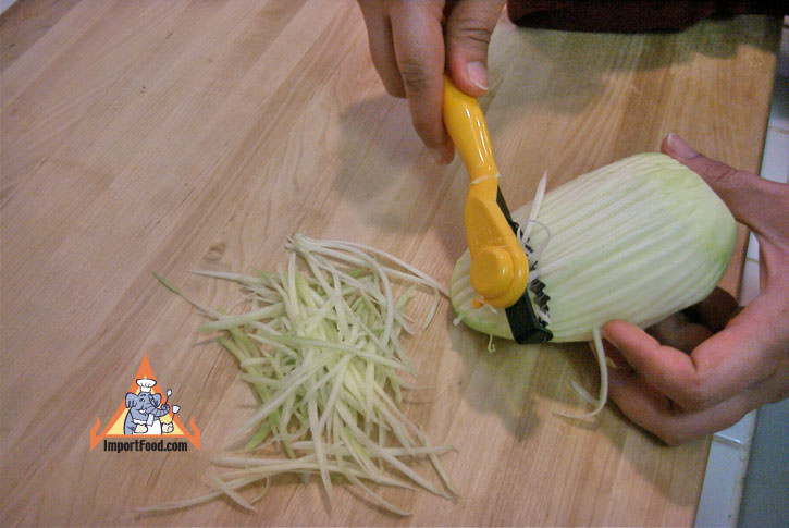 Peel and shred green mango